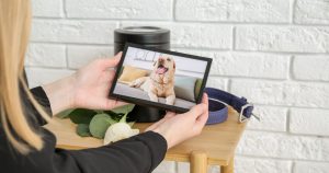 Ženska, ki gleda v fotografijo svojega psa – trenutek žalosti in hvaležnosti.